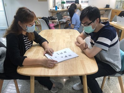 諮詢師與青年面對面諮詢，說明診斷測驗結果